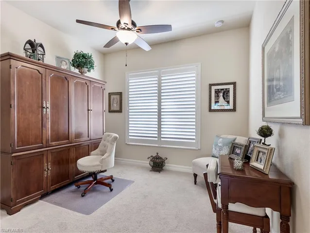 a living room with furniture a window and a ceiling fan