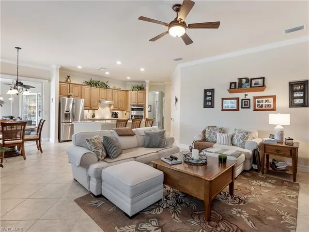 a living room with furniture kitchen view and a chandelier