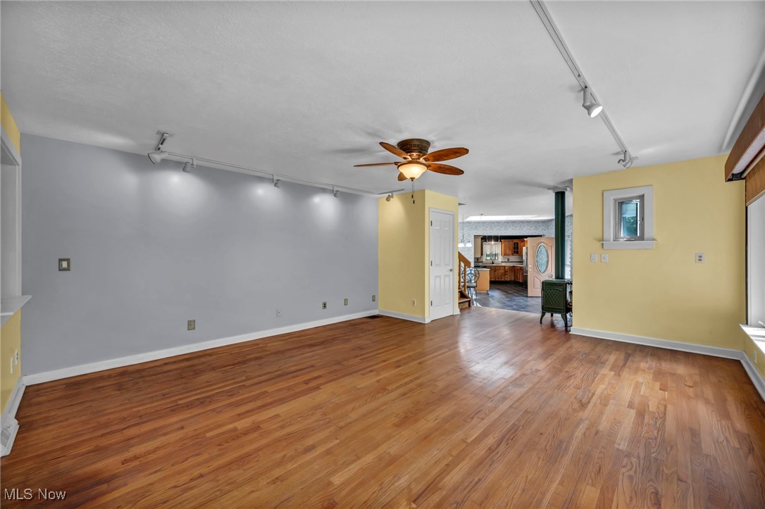 10982 Root Road Columbia Station, OH 44028 - Photo 8 of 49 Unfurnished living room with track lighting, ceiling fan, and light wood-style flooring