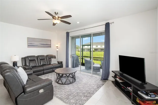 a living room with furniture a flat screen tv and a large window