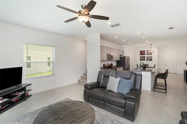 a living room with furniture a flat screen tv and a window