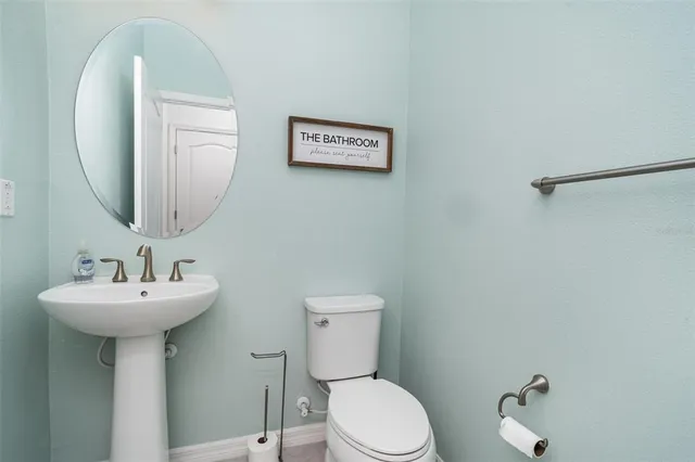 a bathroom with a sink mirror and toilet