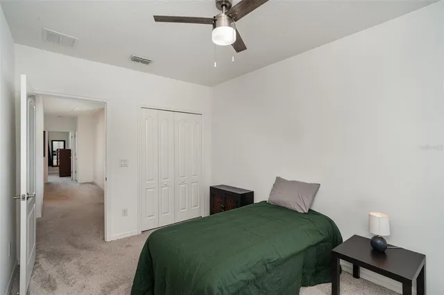 a bedroom with a bed and a lamp on the dresser
