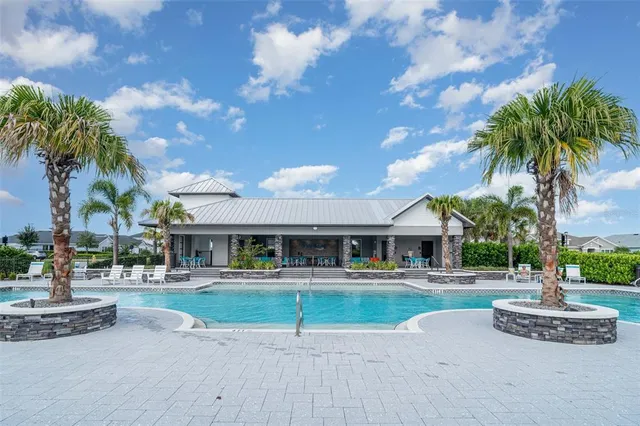 a view of a swimming pool with a lawn chairs under an umbrella