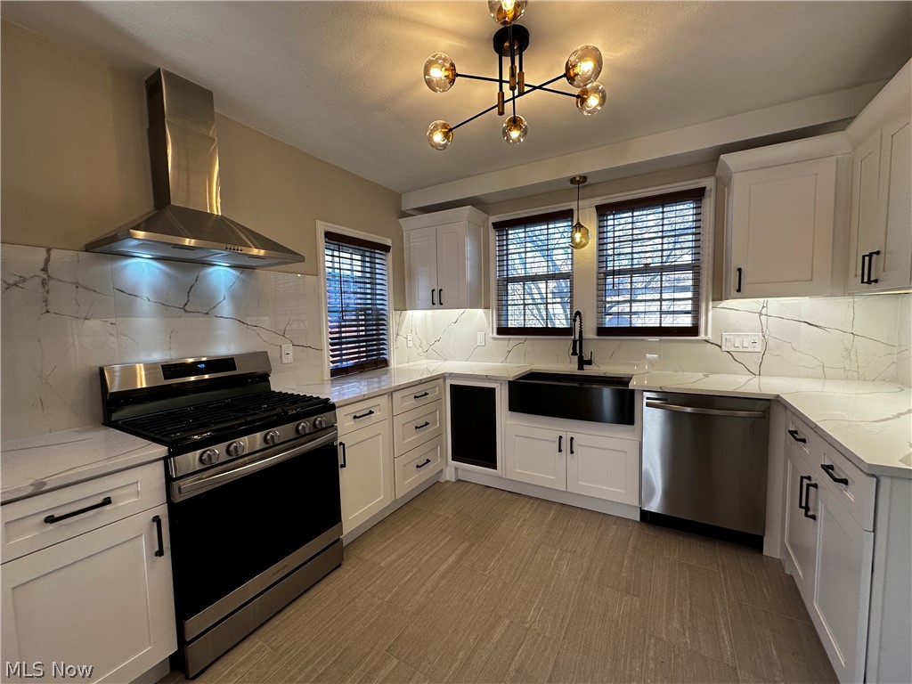 2447 Dysart Road Cleveland, OH 44118 - Photo 6 of 20 Kitchen featuring wall chimney exhaust hood, gas range oven, backsplash, light stone counters, and dishwasher