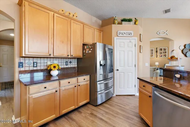 a kitchen with stainless steel appliances granite countertop a refrigerator sink and cabinets