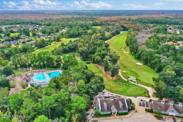 an aerial view of a swimming pool with outdoor seating