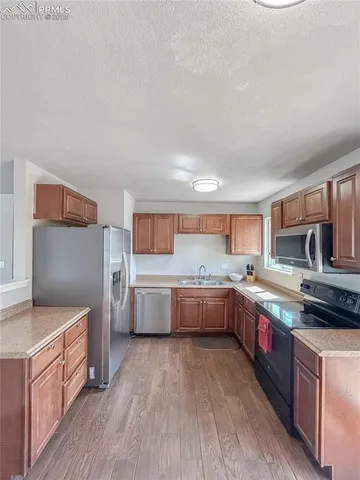 a large kitchen with a lot of counter space and wooden floor