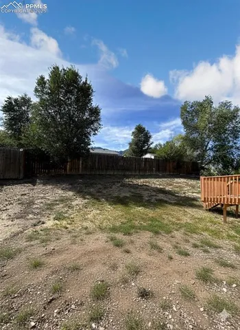 a view of a yard with wooden fence