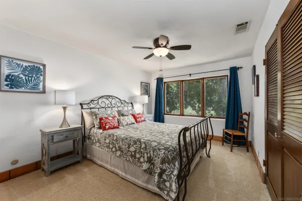 a balcony of a house with wooden floor outdoor seating and yard in the back
