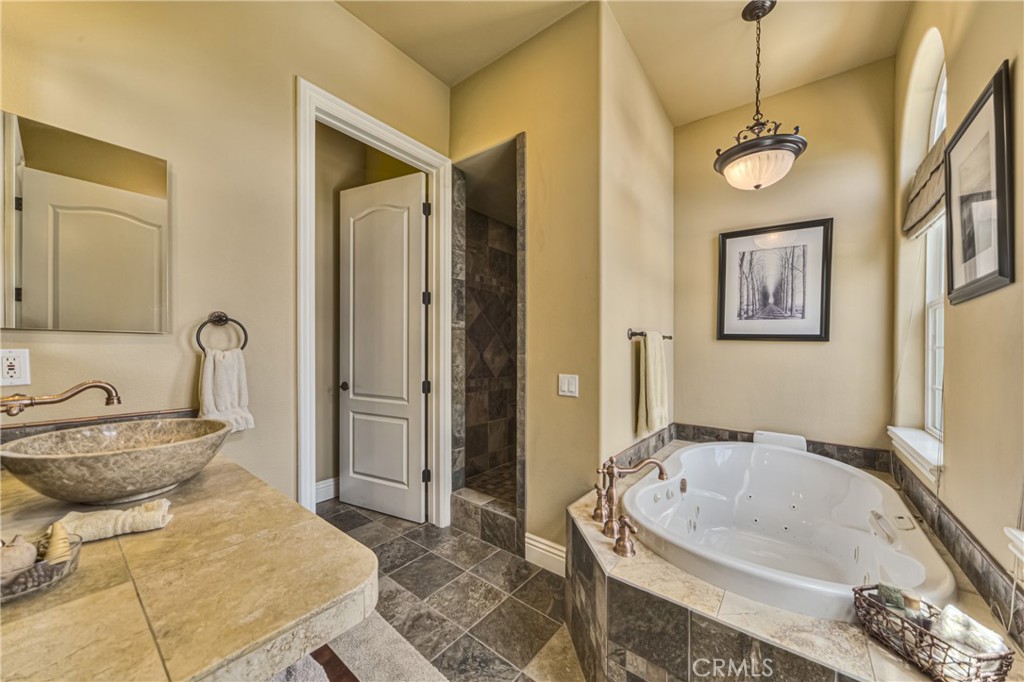 39700 Berenda Road Temecula, CA 92591 - Photo 27 of 71 a bathroom with a tub sink and mirror