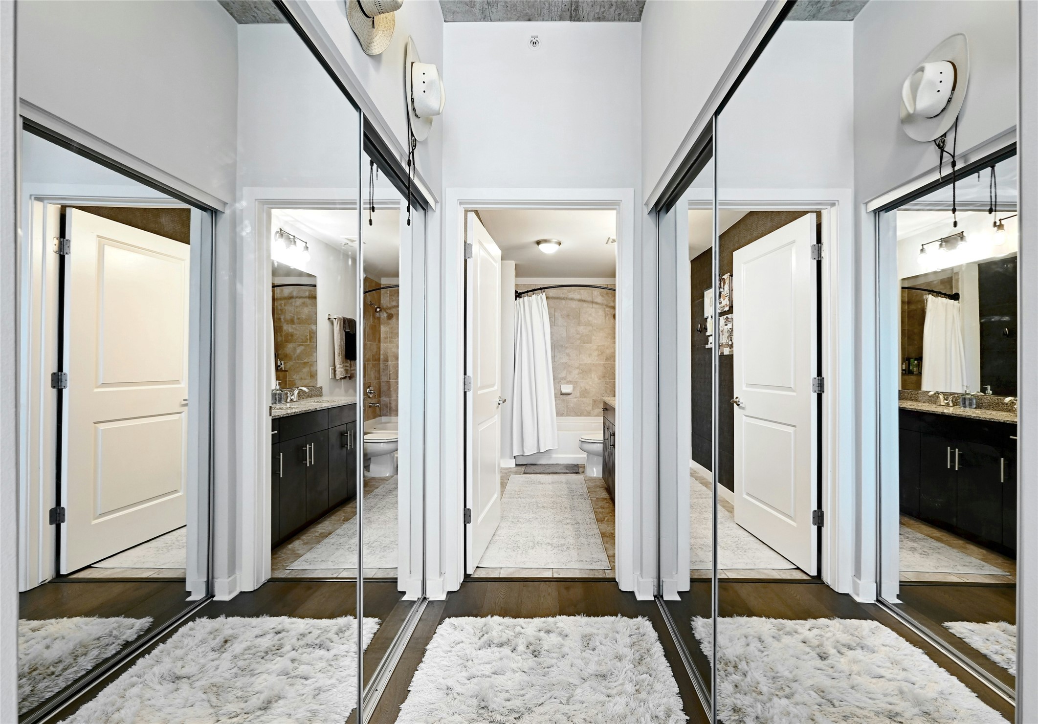 360 Nueces Street, Unit 1809 Austin, TX 78701 - Photo 15 of 25 Hallway with floor-to-ceiling mirrored closet doors, dark wood-finish flooring, and white trim