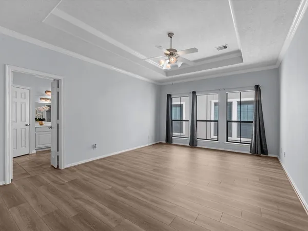 a view of an empty room with window and wooden floor