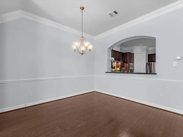 a view of wooden floor and a chandelier in a room