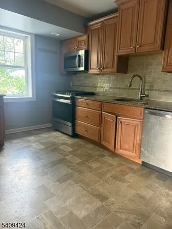 a kitchen with stainless steel appliances granite countertop a stove a sink and a white cabinets