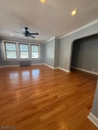 a view of an empty room with window and wooden floor
