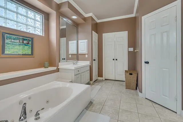 a bathroom with a tub a sink and a large mirror