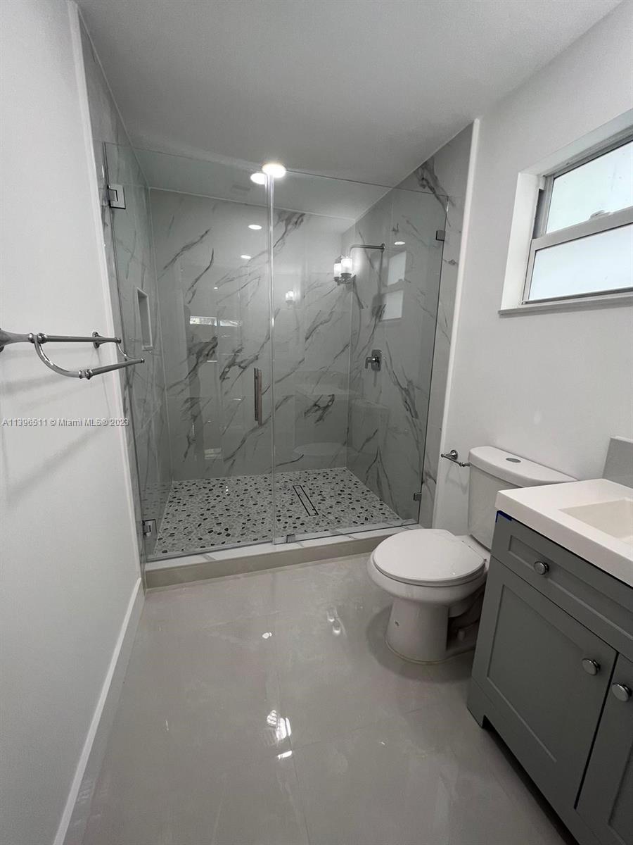 2180 Southwest 20th Street Miami, FL 33145 - Photo 15 of 31 a bathroom with a granite countertop toilet a sink a mirror and a shower