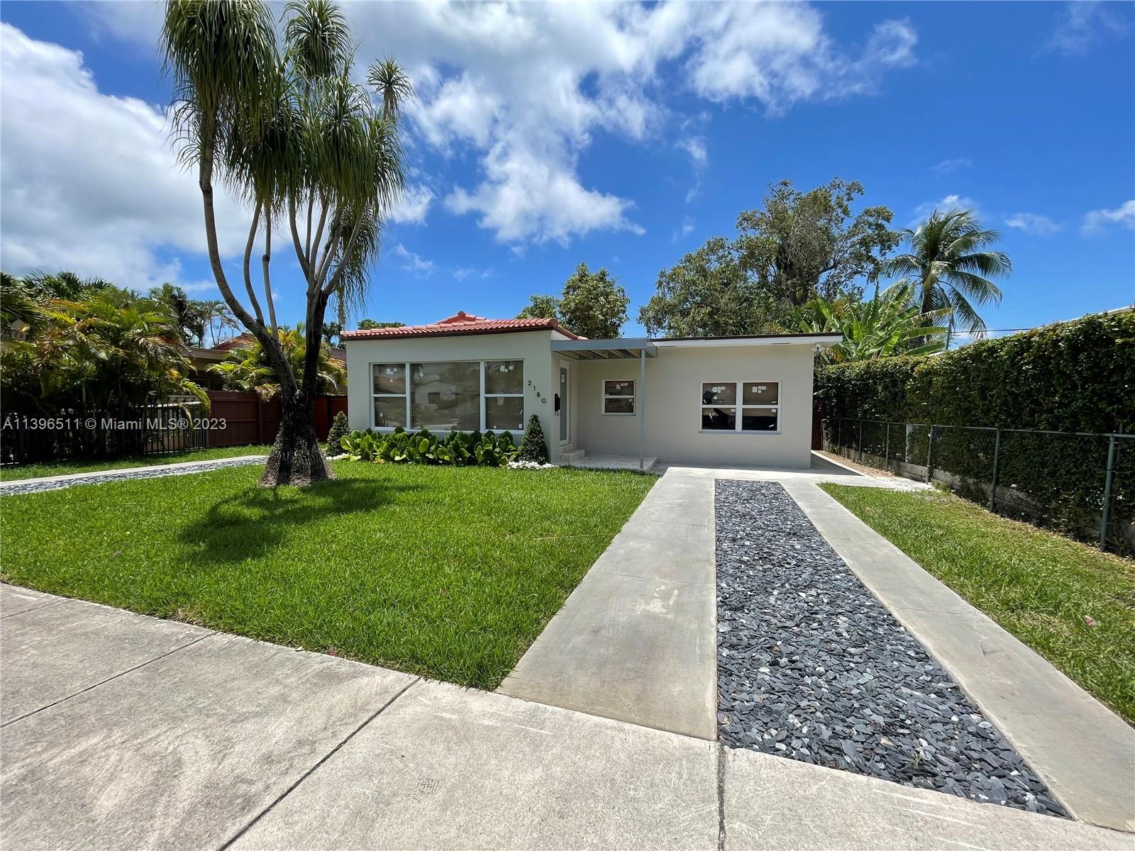 2180 Southwest 20th Street Miami, FL 33145 - Photo 2 of 31 front view of a house with a yard and potted plants