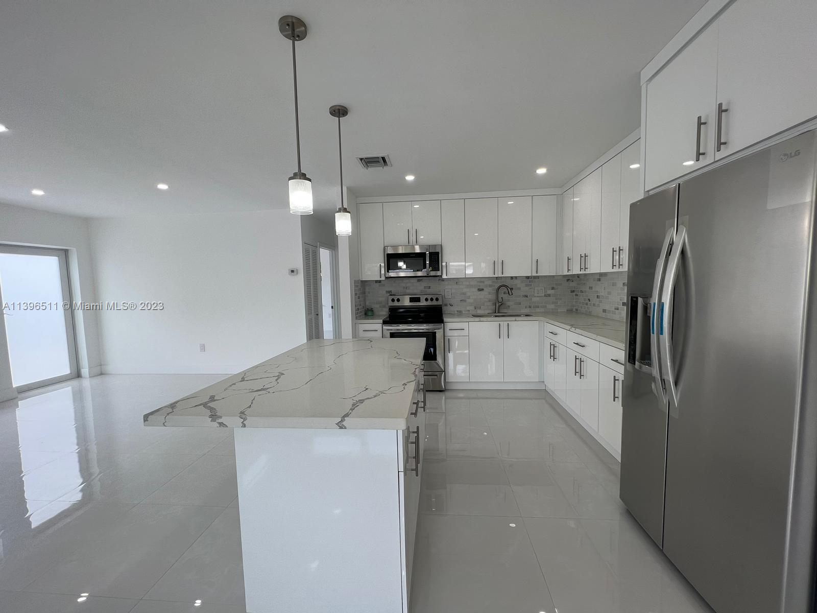 2180 Southwest 20th Street Miami, FL 33145 - Photo 7 of 31 a kitchen with a refrigerator a stove top oven a counter space and a sink