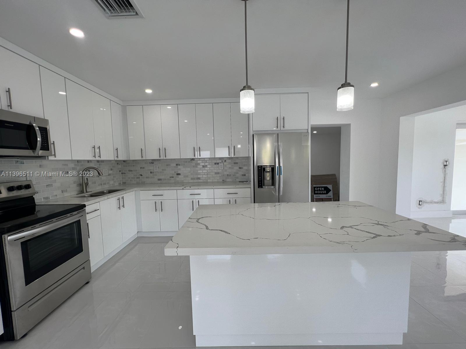 2180 Southwest 20th Street Miami, FL 33145 - Photo 8 of 31 a kitchen with stainless steel appliances granite countertop a sink a stove a refrigerator a center island and cabinets