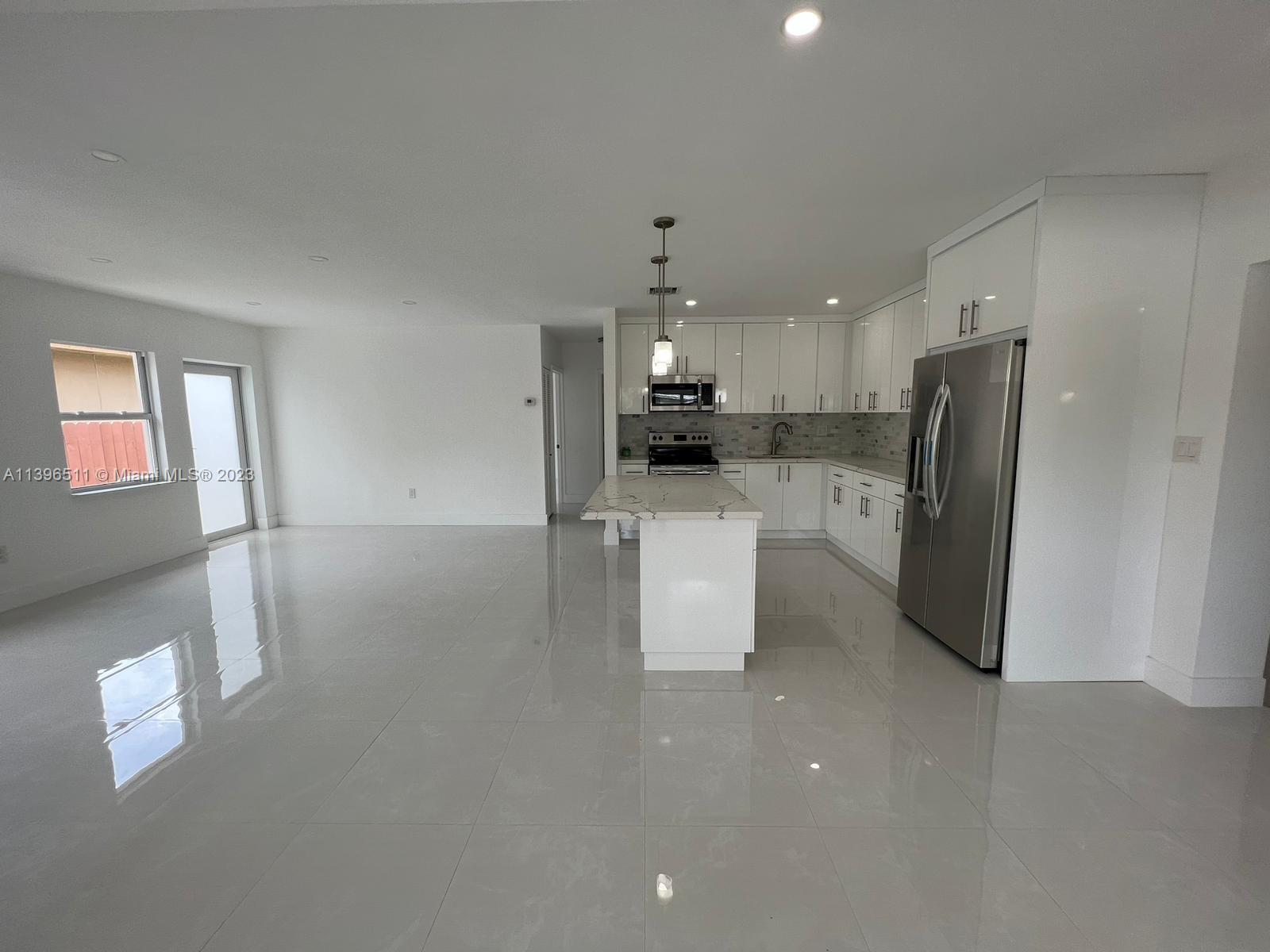 2180 Southwest 20th Street Miami, FL 33145 - Photo 9 of 31 a kitchen with stainless steel appliances a refrigerator sink and microwave