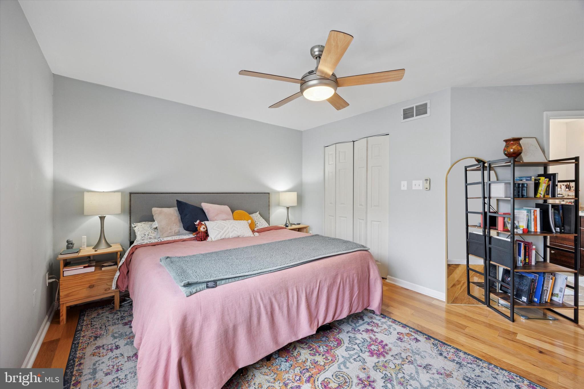 814 South Sheridan Street, Unit 2E Philadelphia, PA 19147 - Photo 15 of 24 a bedroom with a bed a book shelf and a chandelier