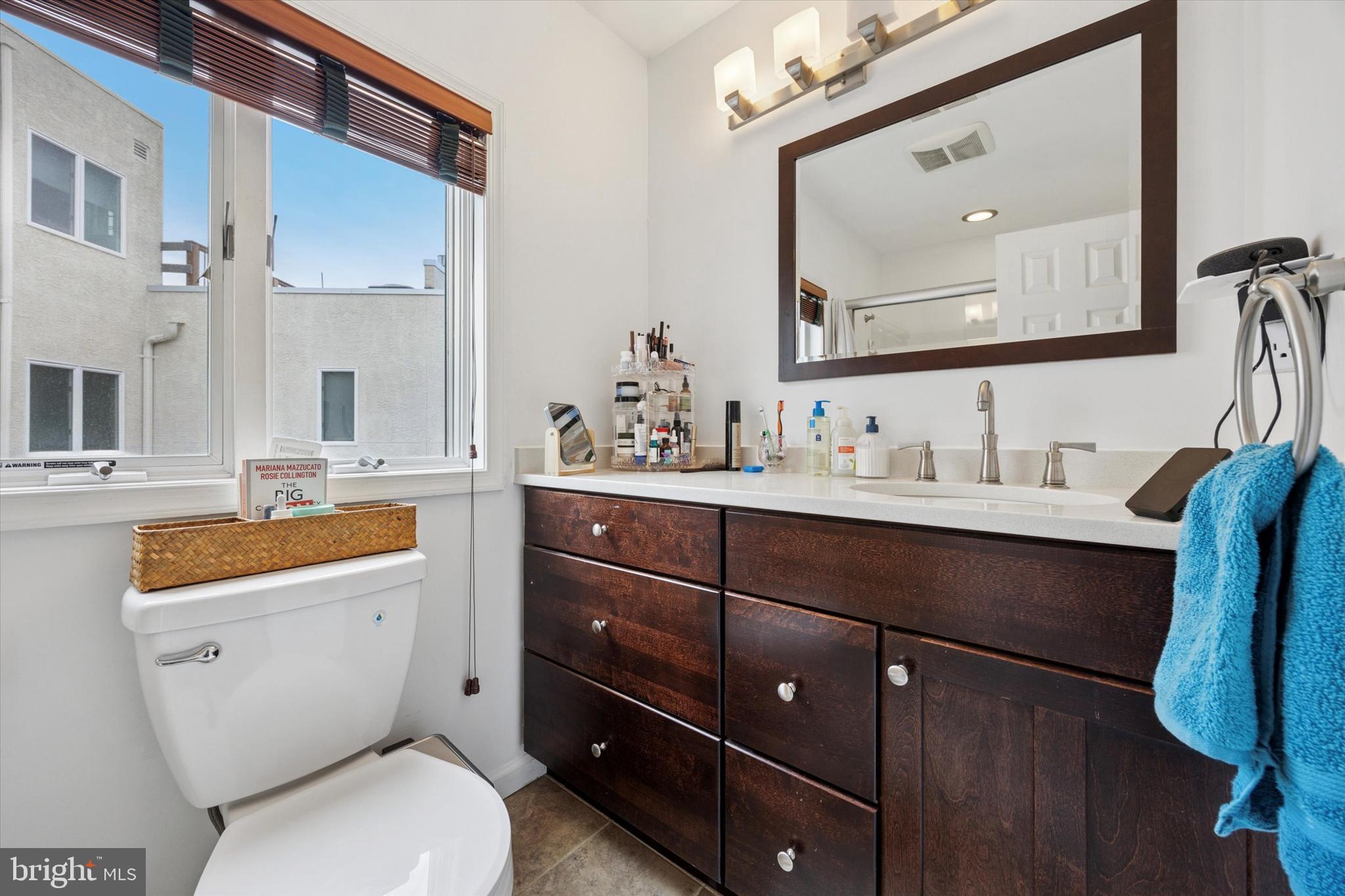 814 South Sheridan Street, Unit 2E Philadelphia, PA 19147 - Photo 16 of 24 a bathroom with a toilet a sink a vanity and mirror