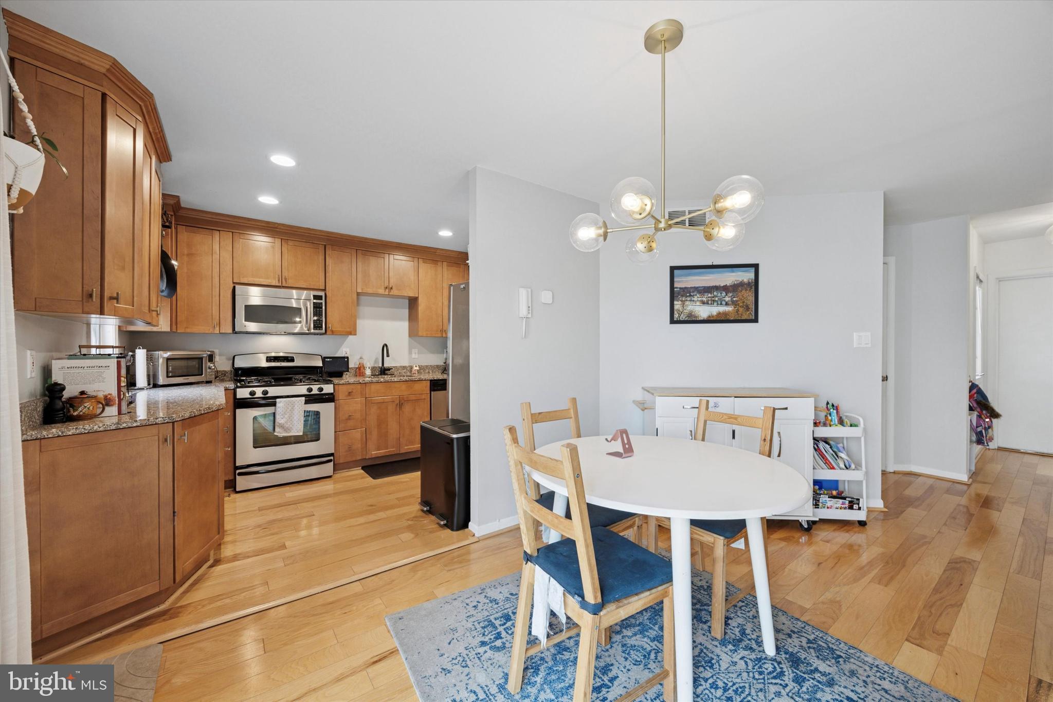 814 South Sheridan Street, Unit 2E Philadelphia, PA 19147 - Photo 4 of 24 a kitchen with granite countertop stainless steel appliances a dining table and chairs