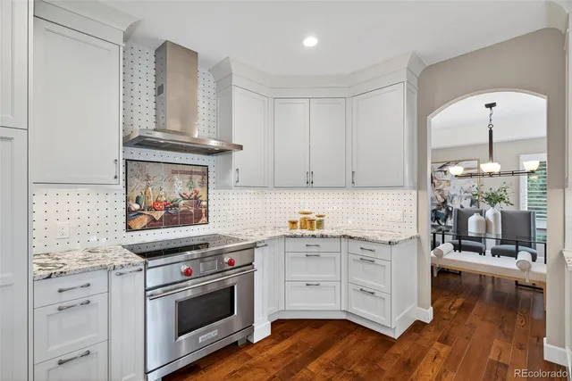 a kitchen with stainless steel appliances white cabinets and wooden floor