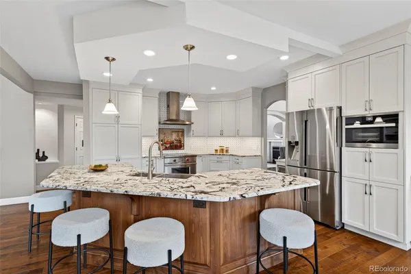 a kitchen with stainless steel appliances granite countertop a kitchen island a table and chairs