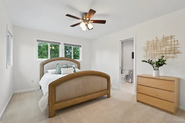 a bed sitting in a bedroom next to a window and a chandelier