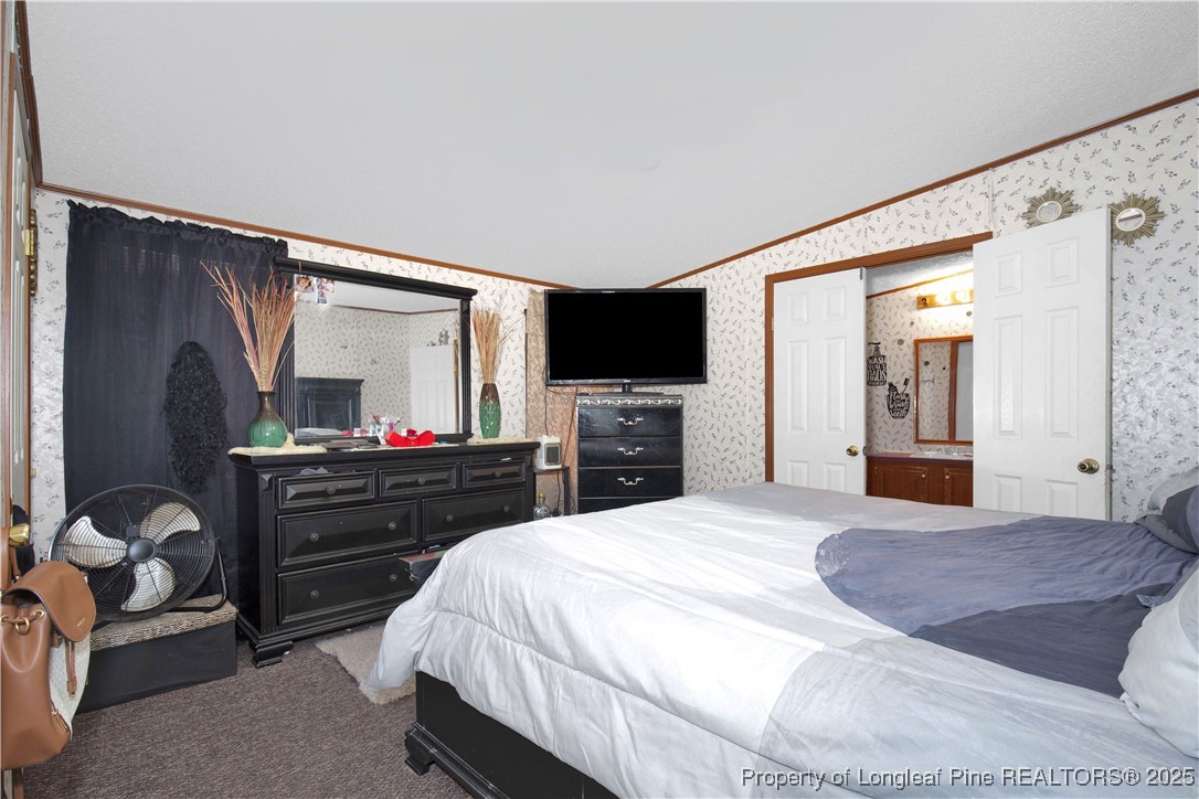 5065 Tobacco Road Orrum, NC 28369 - Photo 17 of 31 a bedroom with a bed and a flat screen tv