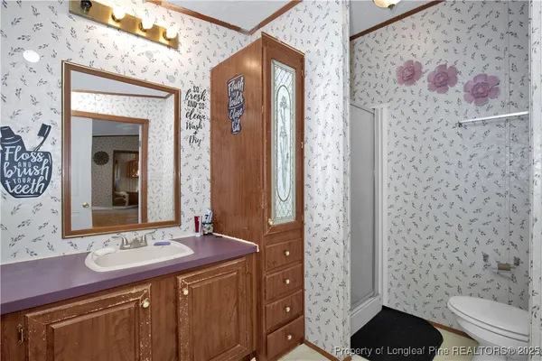 a bathroom with a sink a toilet and shower