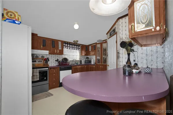 a kitchen with stainless steel appliances granite countertop a stove a kitchen island a sink and cabinets