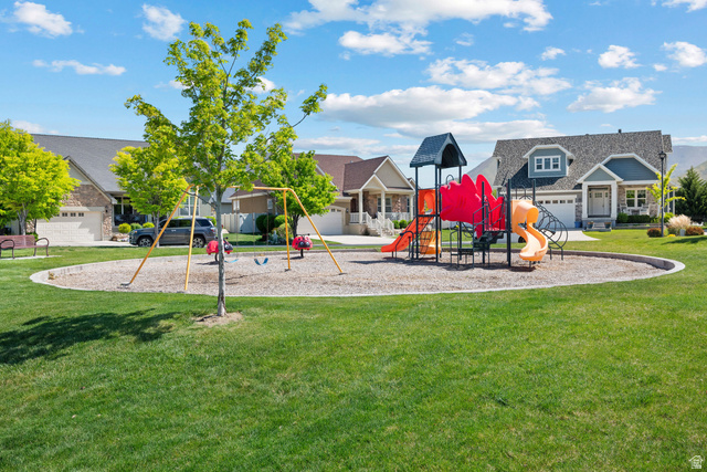 927 Iris Lane Mapleton, UT 84664 - Photo 30 of 31 Community park featuring a playground structure with multiple slides and swings, surrounded by a manicured lawn
