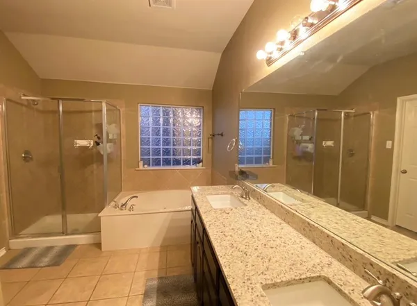 a bathroom with a granite countertop sink a large mirror and shower
