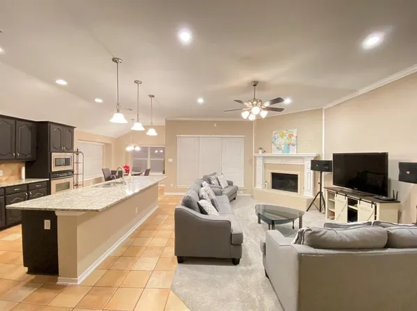 a living room with furniture a flat screen tv and a chandelier