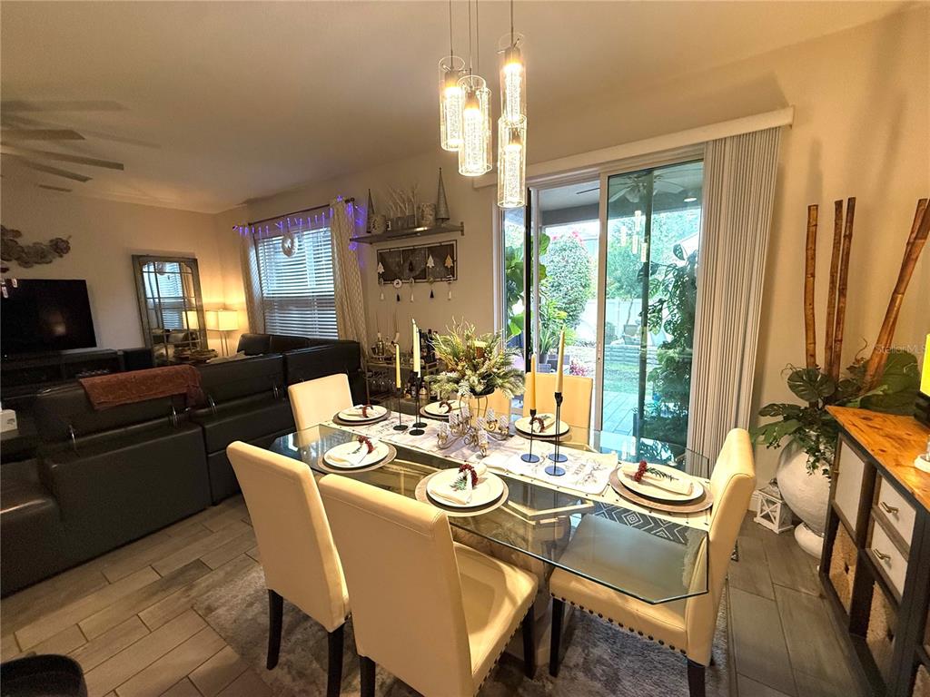 11104 Spring Point Circle Riverview, FL 33579 - Photo 21 of 52 a dining room with furniture a chandelier and large windows