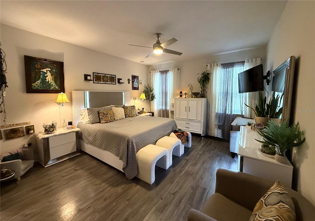 11104 Spring Point Circle Riverview, FL 33579 - Photo 22 of 52 a bedroom with a bed couch tv and wooden floor