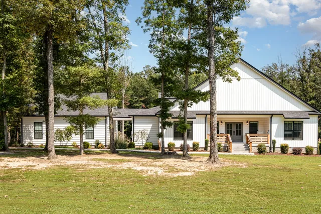 a front view of a house with swimming pool and furniture