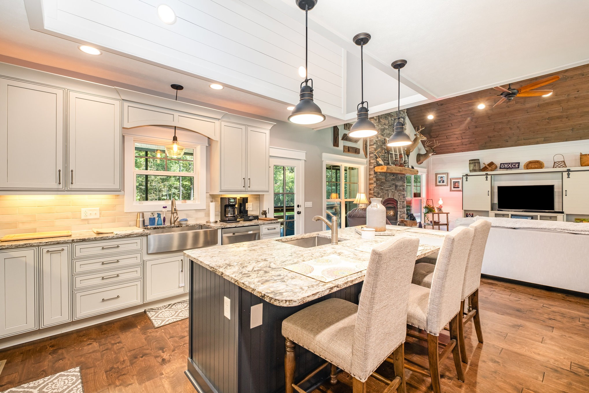 8129 Hollow Springs Road Bradyville, TN 37026 - Photo 28 of 42 a large kitchen with granite countertop a stove a sink a dining table and chairs with wooden floor