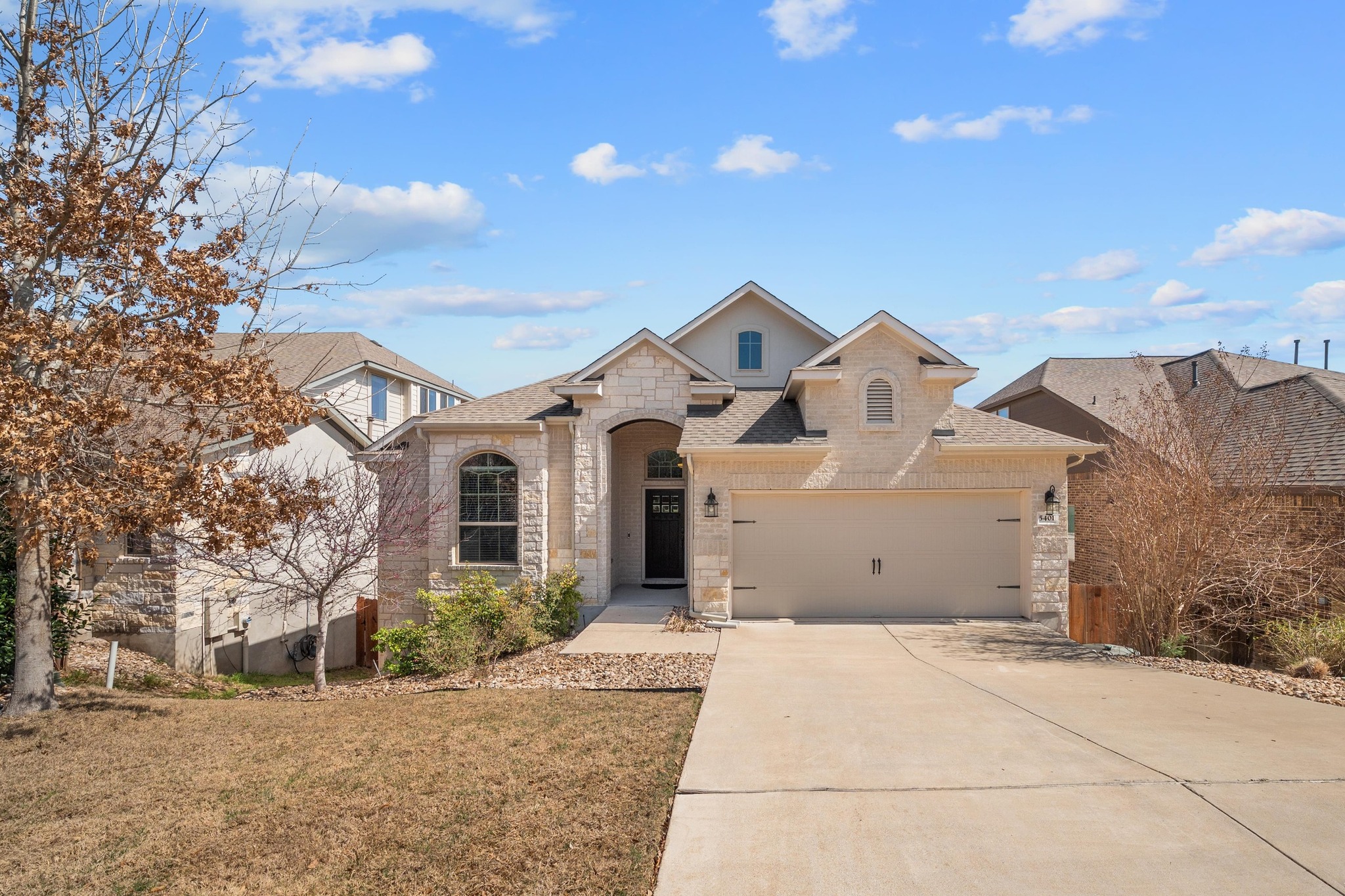 5401 Buchanan Draw Road Austin, TX 78738 - Photo 1 of 1 French country style house featuring a garage, stone siding, roof with shingles, and driveway
