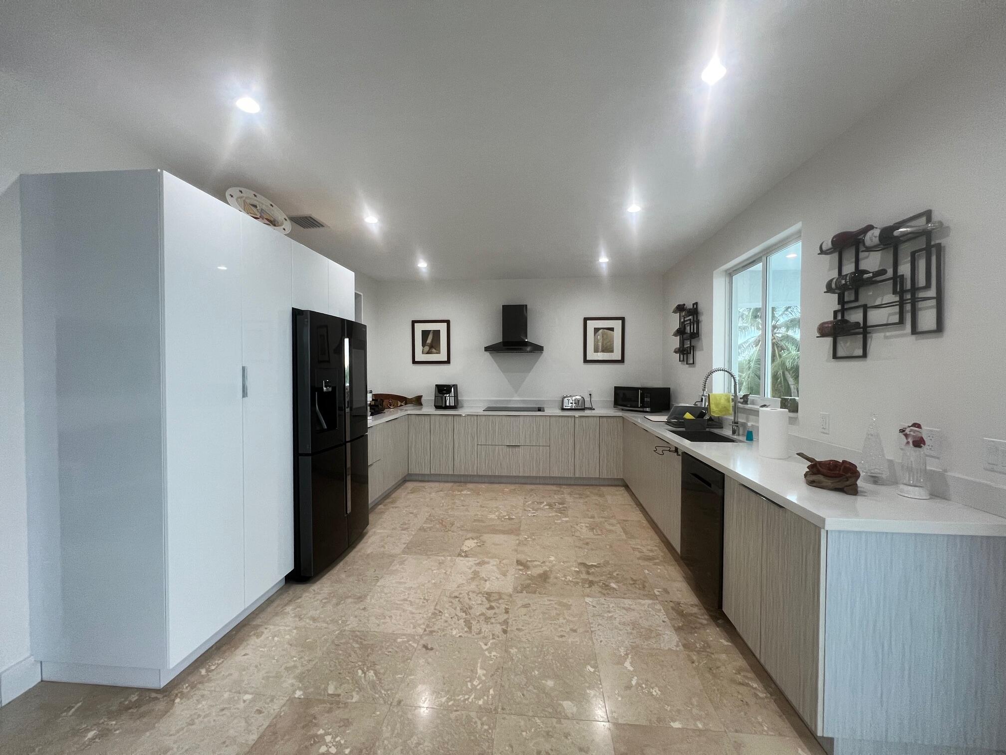 4 Pelican Road Key Largo, FL 33037 - Photo 4 of 15 a large white kitchen with a refrigerator and a sink
