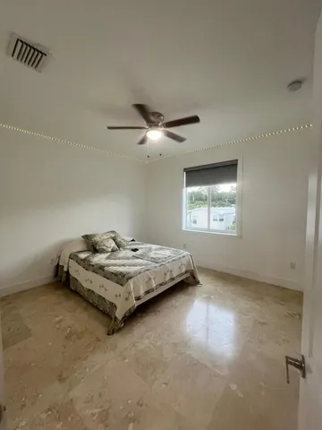 a spacious bedroom with a bed and large window