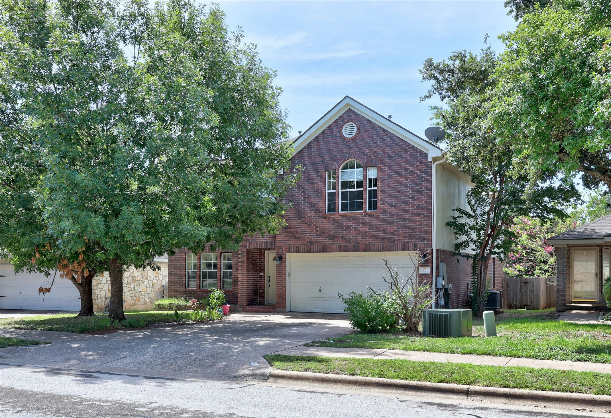 View of front of home featuring brick siding, concrete driveway, and a garage