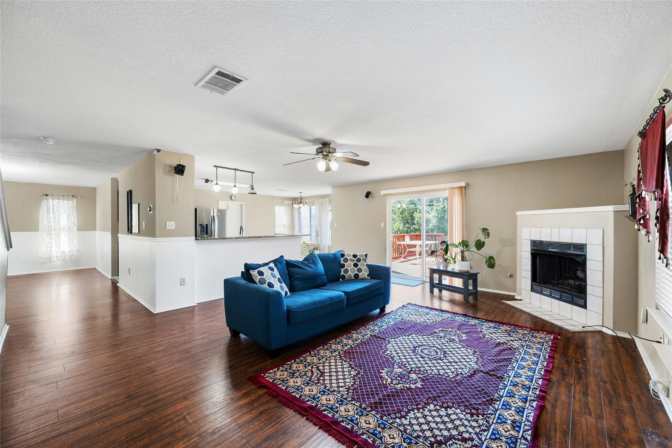 3618 Windhill Loop Round Rock, TX 78681 - Photo 12 of 30 Living room featuring a fireplace, ceiling fan, dark wood-flooring, and a textured ceiling