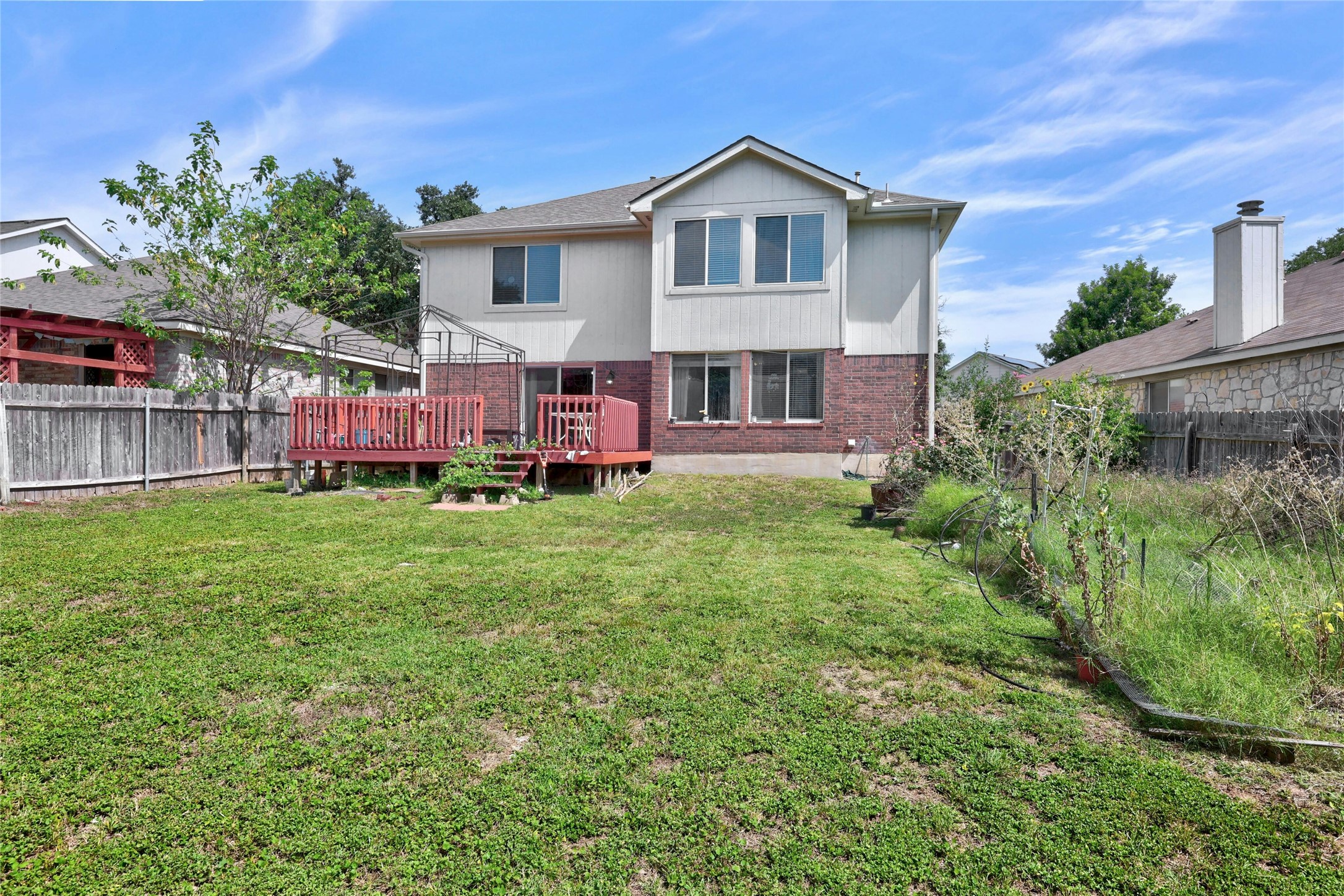3618 Windhill Loop Round Rock, TX 78681 - Photo 28 of 30 Back of house featuring a fenced backyard, a deck, garden area has been cleared.