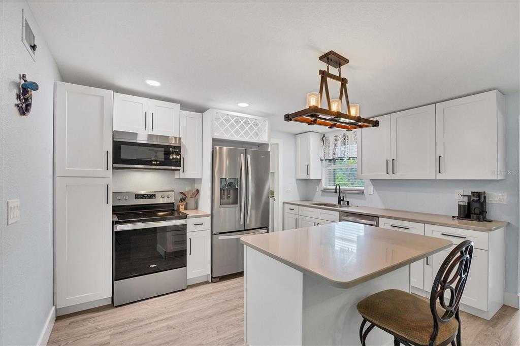 2254 Hayworth Road Port Charlotte, FL 33952 - Photo 17 of 48 a kitchen with stainless steel appliances granite countertop a sink a stove a refrigerator cabinets and a dining table