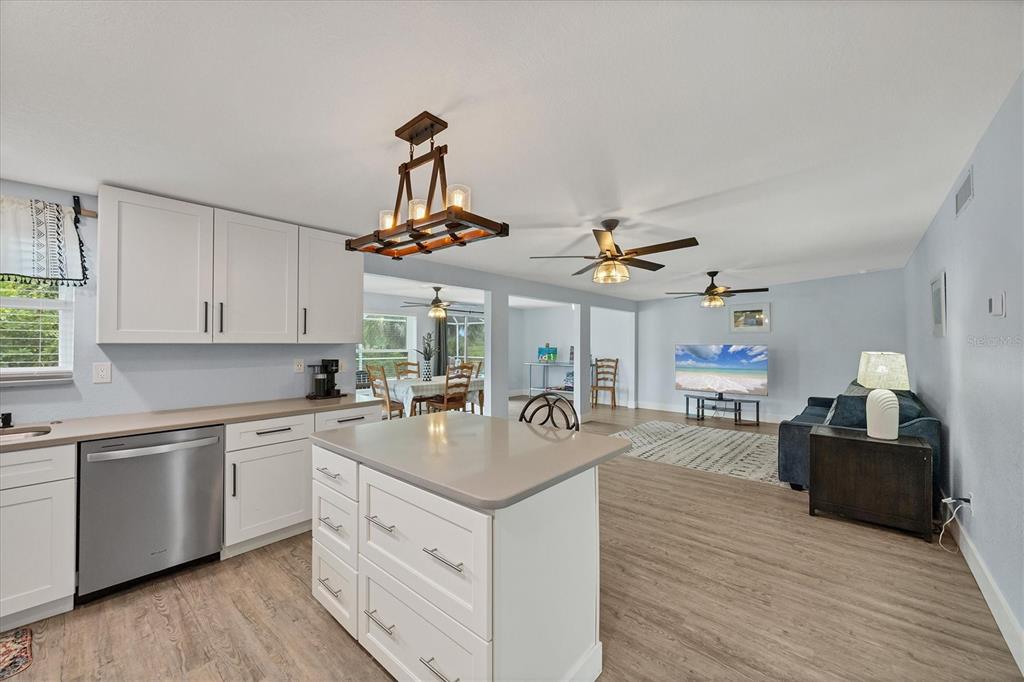 2254 Hayworth Road Port Charlotte, FL 33952 - Photo 21 of 48 a kitchen with a sink dishwasher a stove top oven a dining table and chairs with wooden floor